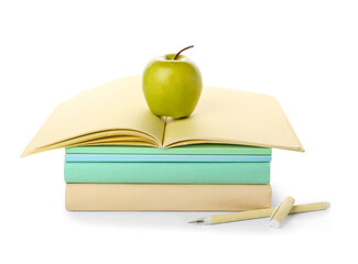 Green apple and school supplies with open notebook and pens on white background