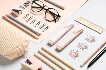 Eyeglasses and different stationery on color background, closeup