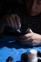 Photograph of a woman cleaning a camera lens. Concept of photography.