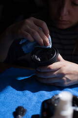 Photograph of a woman cleaning a camera lens. Concept of photography.