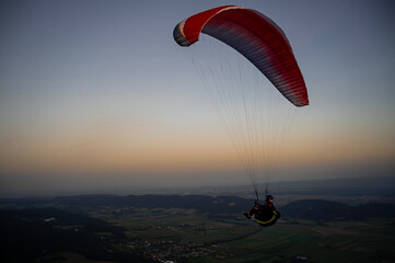Paragliding concept, a paraglider pilot fly in the sky at sunset or sunrise on the nature landscape...