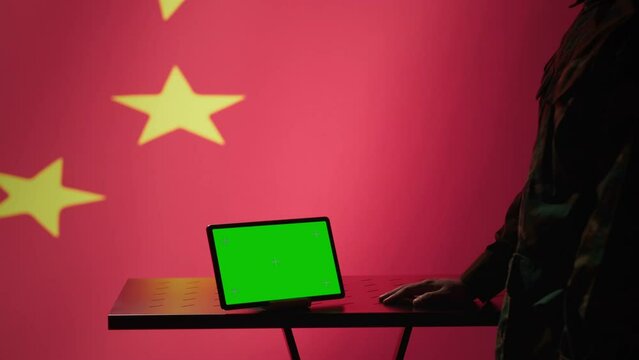 Chinese intelligence agency operator using green screen tablet to do mass propaganda on internet. CCP government secret agent engaging in psychological operations with mockup device, camera A