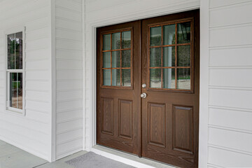 Brown Double Wooden Doors With Glass Panels In White House Exterior