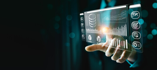Businessman working on a laptop with a holographic interface for big data analytics, artificial intelligence, data management, and strategic decision making. Enhancing efficiency, driving innovation