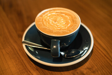 A cup of coffee with latte art on a wooden table