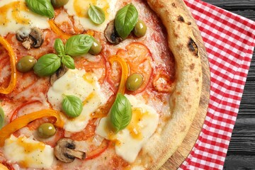 Delicious vegetarian pizza on black wooden table, closeup