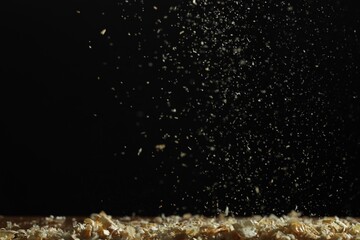 Dry natural sawdust falling on black background