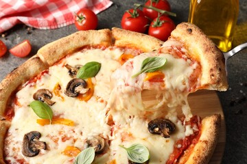 Taking piece of delicious vegetarian pizza at table, closeup