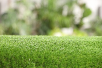 Naklejka premium Green artificial grass against blurred background, closeup