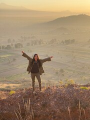 Young Mexican Girl with triumph pose in the top of a mountain in San Jerónimo Tecuanipan, Puebla, Mexico