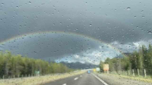 Rainy day driving, waterdrops on car window, Rainbow