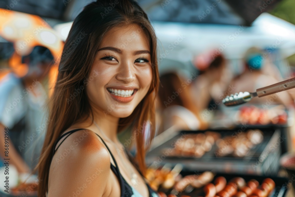 Wall mural portrait of a smiling young woman attending a barbecue