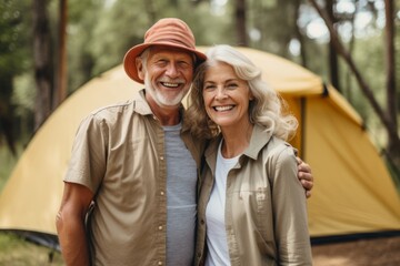 Fototapeta premium Portrait of a smiling couple in front of tent outdoors