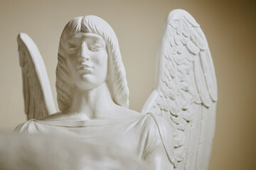 Medium closeup of gypsum sculpture of angel in catholic church interior
