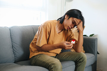 Young Asian Man Touching His Head Suffering From Nosebleed Or Epistaxis And Using Paper Tissue For...
