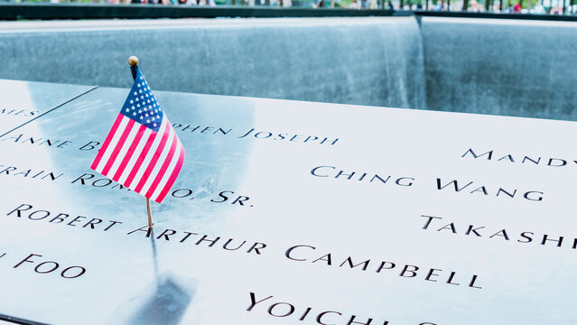 Memorial at Ground Zero Manhattan for September 11 Terrorist Attack with an American Flag Standing near the Names of Victims Engraved. Patriot Day - New York NY USA 2023-07-30