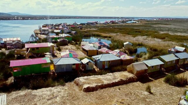 Drone descends to ground over Uros Island floating homes on Lake Titicaca