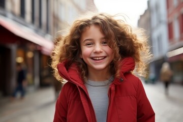 Fototapeta premium Outdoor portrait of a cute little girl with curly hair in the city