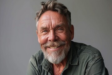 Obraz premium Portrait of a smiling senior man with grey hair and beard.