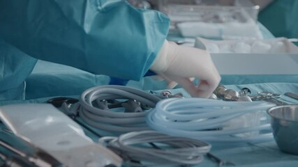 Hands in gloves, medical assistant preparing tools for operation