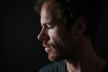 Fototapeta premium Portrait of a handsome young man with a beard on a dark background