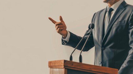 Man in a suit delivers a speech at a podium, emphasizing a point with a gesture. The image highlights the professionalism and authority of public speaking.