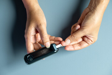 Woman's hands checking diabetes and hyperglycemia with digital blood sugar meter. Healthcare and medical concept	
