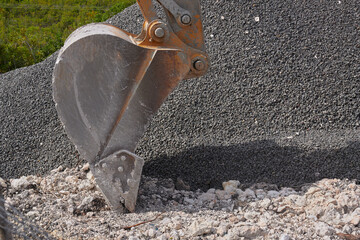 heavy construction machinery, excavator bucket working with gravel and crushed stone © Andrei