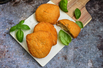 
 Crispy  deep fried home made     chicken Cordon bleu with cheese   and ham  and french fries on wooden rustic background.  