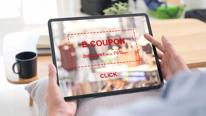 Hand holding digital tablet with discount coupon code on screen to get the shopping on line sale promotion, on line shopping ,digital marketing business 
