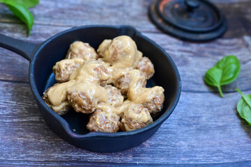 Homemade Swedish Meatballs  With creamy gravy sause in black pan skillet.Swedish cuisine.