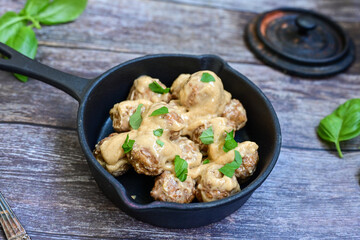 Homemade Swedish Meatballs  With creamy gravy sause in black pan skillet.Swedish cuisine.