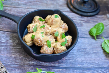 Homemade Swedish Meatballs  With creamy gravy sause in black pan skillet.Swedish cuisine.