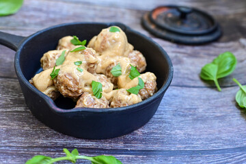 Homemade Swedish Meatballs  With creamy gravy sause in black pan skillet.Swedish cuisine.