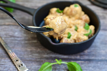 Homemade Swedish Meatballs  With creamy gravy sause in black pan skillet.Swedish cuisine.