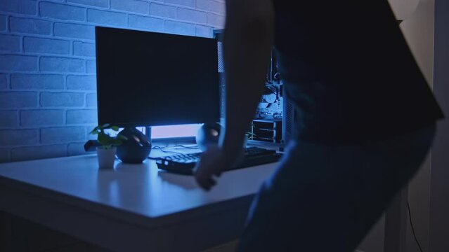 Man is working at professional computer with backlight. Clip. Man is working at computer with backlight. Programmer or gamer with stylish computer setup