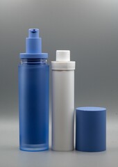 Two cosmetic bottles, one blue and one white, with a blue cap
