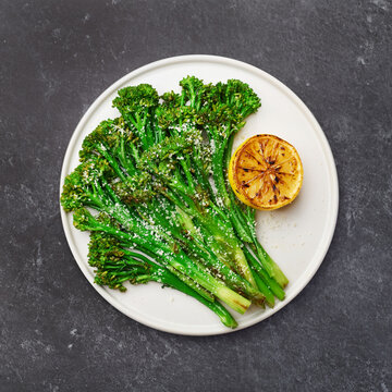 roasted broccolini on a black background, top view