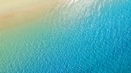 Top view beach sand background for summer vacation concept. Beach nature and summer seawater with sunlight light sandy beach Sparkling sea water	
