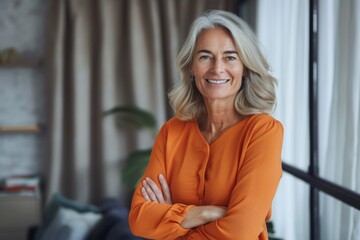 Fototapeta premium Portrait of confident smiling middle aged woman with crossed arms