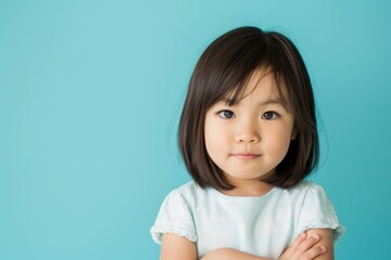 Portrait of cute Asian child posing on neutral background