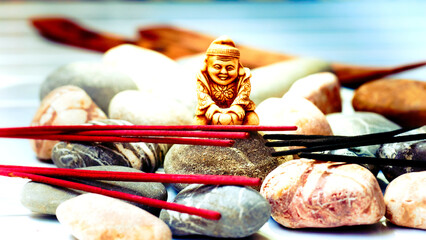 Statuette of a Buddhist monk among incense and various stones
