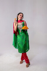 Grinning Hot Woman Model In Punjabi Suit Holding Motichoor Laddu Plate In Hand While Posing In Front Of Camera