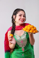 Attractive Model In Punjabi Suit Showing Motichoor Laddu By Looking At Camera 