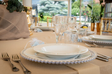 Empty Wedding Reception Hall Table Setting With White Plates and Silverware