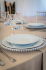 Empty Wedding Reception Table Setting With Plates, Glasses, and Silverware