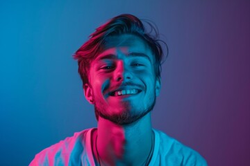 Portrait of young smiling student on dark blue background in neon light