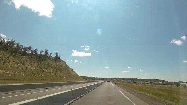 Driving point-of-view traveling across Wyoming state line on interstate highway.