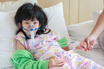 Sick little asian girl inhalation with nebulizer for respiratory treatment