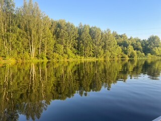 beautiful lake on the shore forest with reflection in water blue sky in reflection of water.